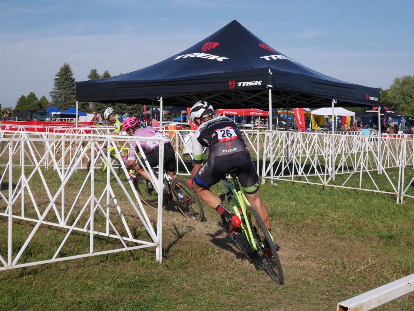 Trek-branded LP Tent at a cyclocross event with racing cyclist in the foreground