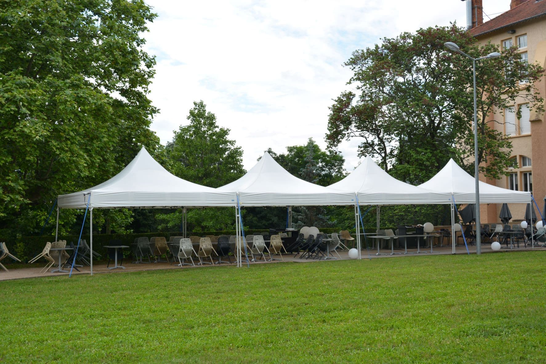 Linked LP Tent pagoda complex on grass with dining furniture — outdoor hospitality configuration
