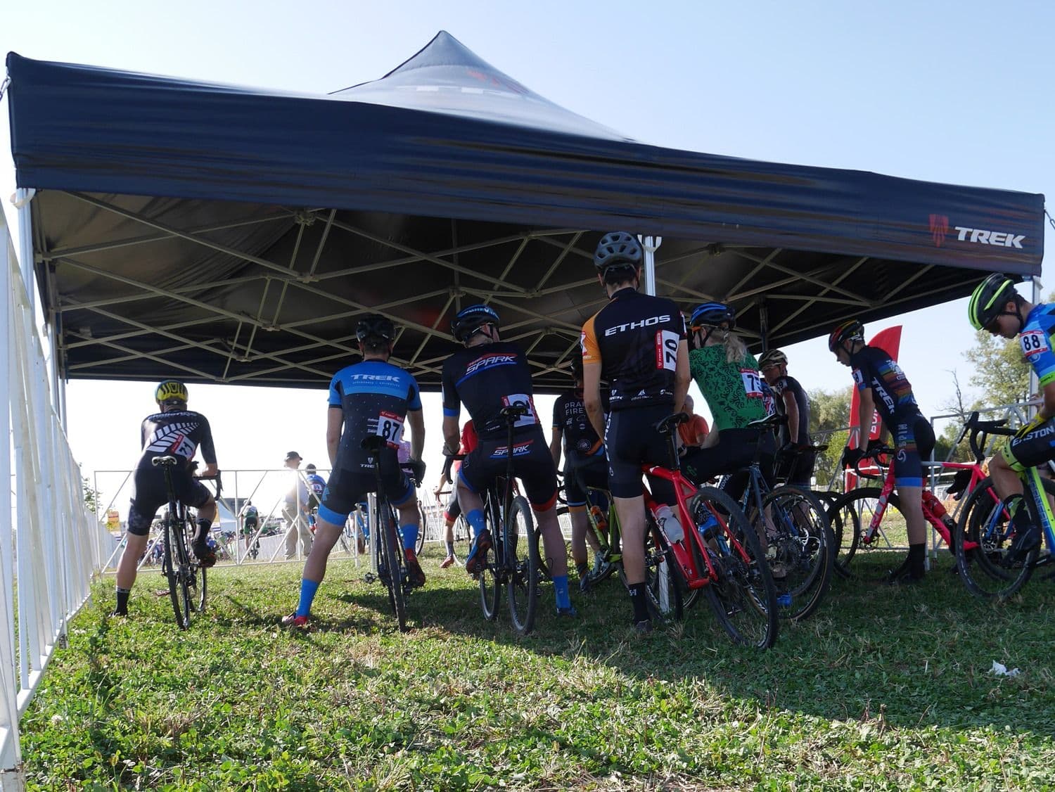 Cyclists sheltering beneath professional outdoor event cover